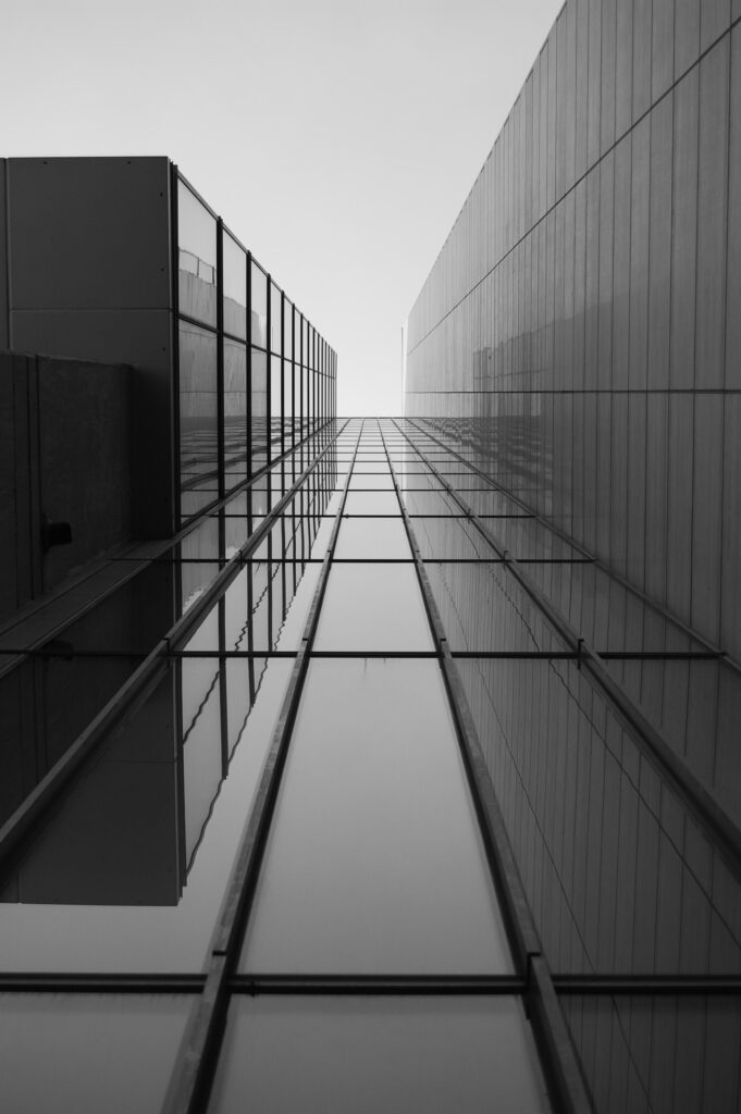 greyscale of a roof of a modern building with glass windows under sunlight greyscale of a roof of a modern building with glass windows under sunlight